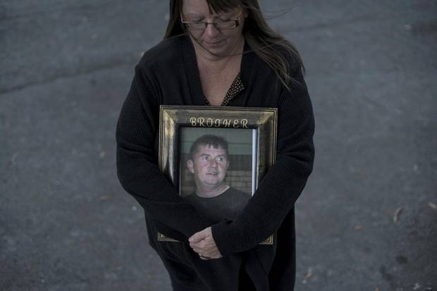 Paulette Raymond cradles a photo of her late brother Tommy while posing in Halifax on Oct. 21, 2017. Mr. Raymond was killed in a work-related accident in 2009.