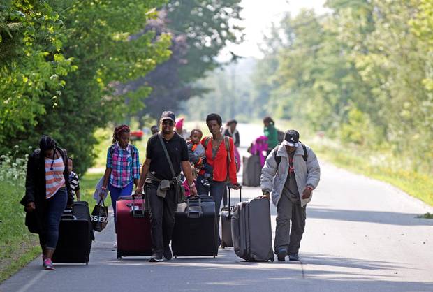 Three families that claimed to be from Burundi walk down Roxham Road to cross into Quebec at the U.S.-Canada border in Champlain, N.Y.