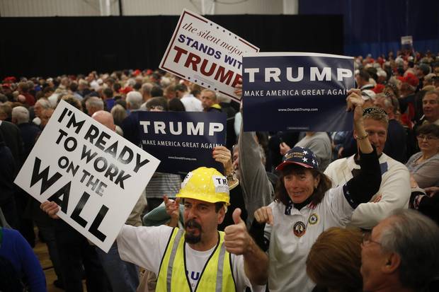 Attendees of a rally hosted by Donald Trump hold signs while waiting for Trump's remarks to begin at the Myrtle Beach Sports Center in Myrtle Beach, South Carolina.