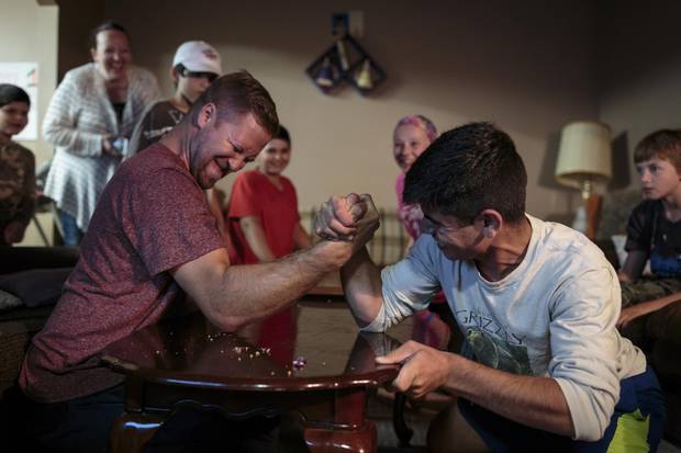 Ziad Hamam, 14, battles Mark Loewen in an arm wrestle during brother Hussein’s first birthday party. Mark and his wife, Amy, are two of the Hamams’ key sponsors.