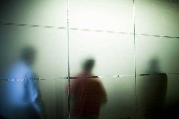 Vision Critical employees are seen through a glass wall during a 2013 meeting.