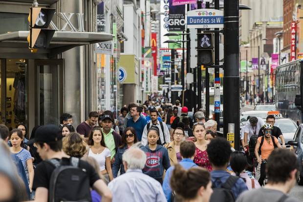 People walk by Dundas Square in Toronto. Canada's demographic profile is much less dire than most advanced economies.