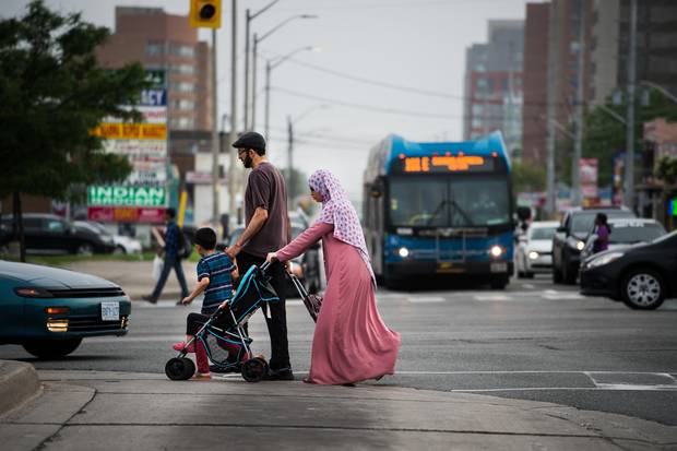 A family crosses Dundas Street at Hurontario Street.