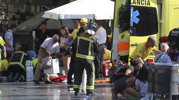 Injured people are treated in Barcelona, Spain, on Aug. 17, 2017, after a white van jumped the sidewalk in the historic Las Ramblas district.