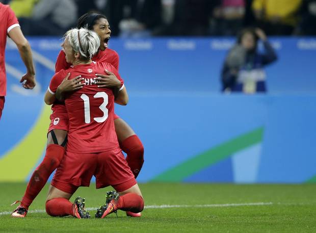 Canada's Sophie Schmidt celebrates with teammate Canada's Ashley Lawrence after scoring her team's first goal during a quarter-final match of the women's Olympic football tournament between Canada and France in Sao Paulo, Brazil, on August 12, 2016.