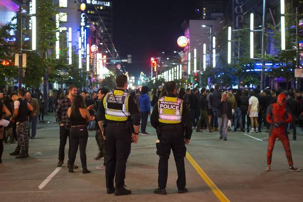 Police officers watch over the crowd on Granville Street in Vancouver.