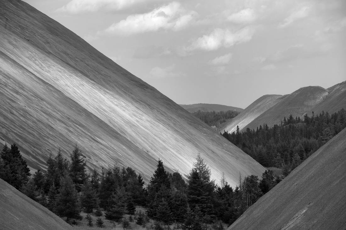 Asbestos mining tailings, known as residue, from the mining of chrysotile asbestos seen in the city of Thetford Mines in Quebec. Up to 300 million tons of this residue has been abandoned by mining operations throughout the region. Thetford Mines was founded in 1876 after the discovery of large asbestos deposits in the area. The city became a hub for one of the world's largest asbestos-producing regions. 