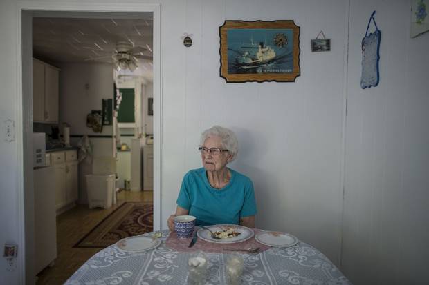 Cressie Roberts sits at her table with a plate of fish and brewis and a cup of tea for a midday meal. ‘I’m not happy about leaving. I’d love to live here forever but I know I can’t,’ says of Little Bay Islands.
