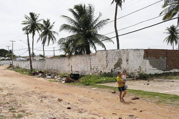 A woman walks with a child in her arms on a sandy road in Joao Pessoa. About 1.5 million people are believed to have been infected by the Zika virus in Brazil since 2014.