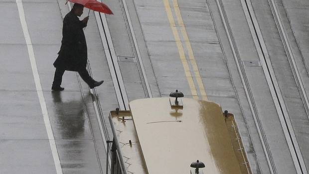 A pedestrian crosses the street behind a cable car in San Francisco in March 2016.