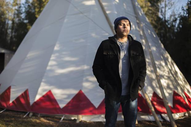 Rhode Thomas, a First Nations student at Trent University in Peterborough who is taking business specialized in Indigenous studies, stands by a tepee on campus in November.