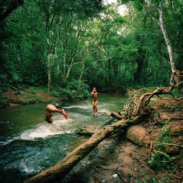 Tamil Flores, 9, left, and her brother Hudson Flores, 6, play in a stream in Guaiviry.