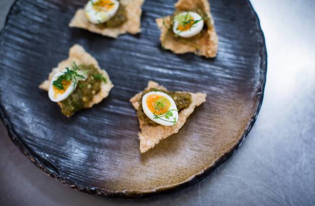 Chiang mai chilli relish with a quail's egg and pork crackling at Maenam in Vancouver.