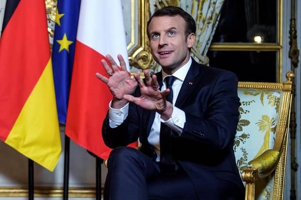 France's President Emmanuel Macron gestures during his meeting with German Chancellor Angela Merkel, at the Elysee Palace, in Paris, Friday, Jan. 19, 2018