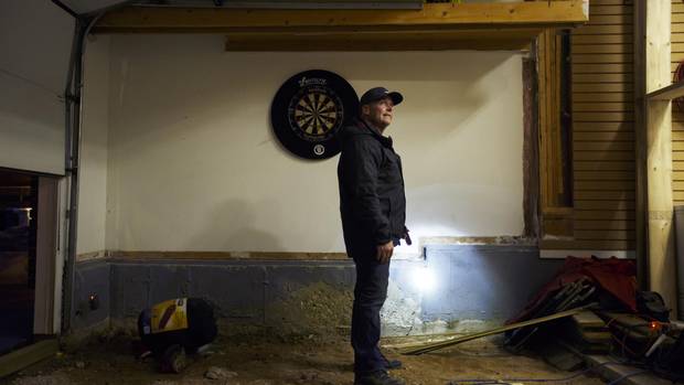 Kirby Byrne surveys damage to his Fort McMurray home last month. The house survived the fire but damage from water-bombing planes made it uninhabitable.