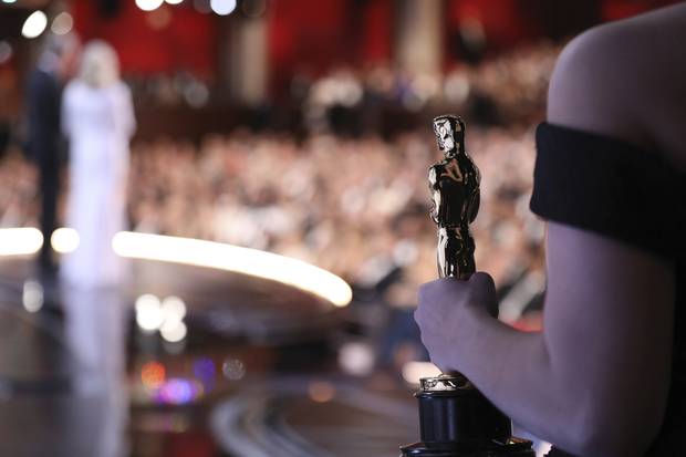 One of the best picture Oscar statuettes appears offstage as Warren Beatty and Faye Dunaway announce the Best Picture winner.