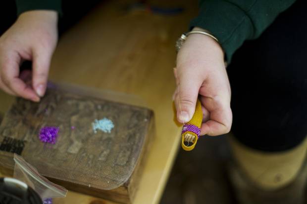 Trent University First Nations student Brittany Kidman-Boyle beads a keychain in the campus teepee.