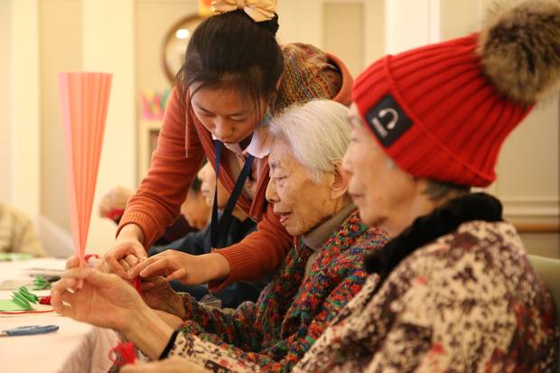 Staff at a Beijing dementia care ward run by Senior Living L’amore lead residents through daily activities.