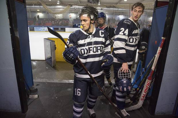 Oxford Blues hockey player Joey Wening checks his stick after leaving the ice between periods on March 3, 2018.
