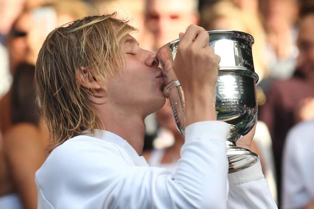 Canada's Denis Shapovalov kisses the trophy after beating Australia's Alex de Minaur in the boy's singles final match on the last day of the 2016 Wimbledon Championships at The All England Lawn Tennis Club in Wimbledon, southwest London, on July 10, 2016.