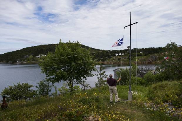 Ray Flynn raises Newfoundland’s flag on his property in Little Bay Islands.
