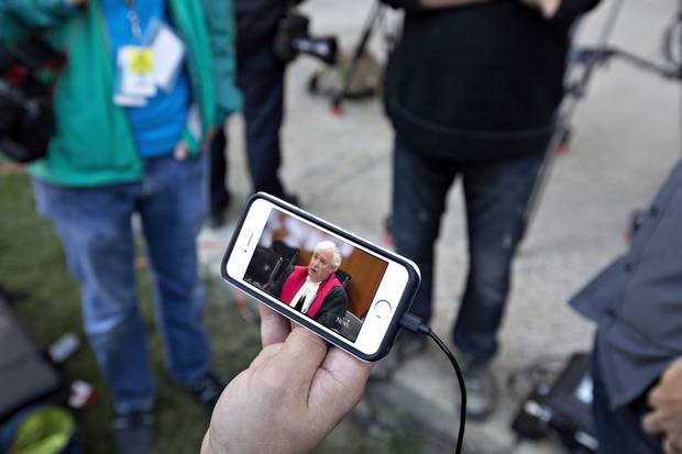 A member of the media watches a live stream of Court of Queen's Bench Justice Denny Thomas deliver his verdict in the Travis Vader case.