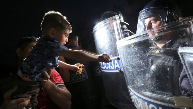 Blocked from entering the Schengen Area through Hungary, thousands of refugees seek alternate routes, including here in Harmica, Croatia on Friday where Slovenian police guard the border.