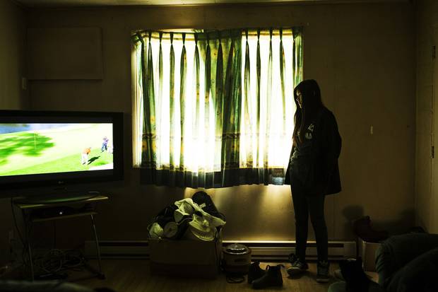Home from school, Marleah looks at the television her father, James Trout, is watching. Mr. Trout, a residential school survivor, has tried to shield Marleah as much as possible, sharing little about his difficult journey to graduating high school.