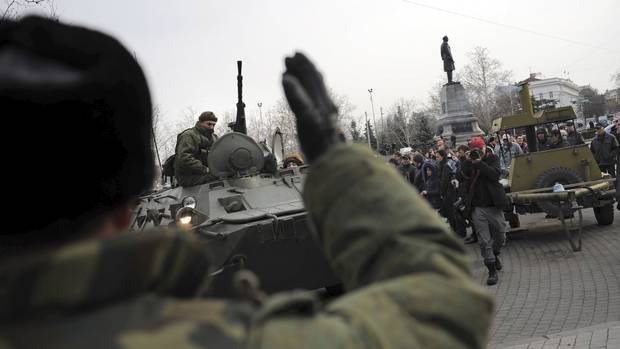 A Russian Army officer helps an armored personnel carrier drive on a street in Sevastopol, Ukraine's Black Sea port, on Feb. 25, 2014.