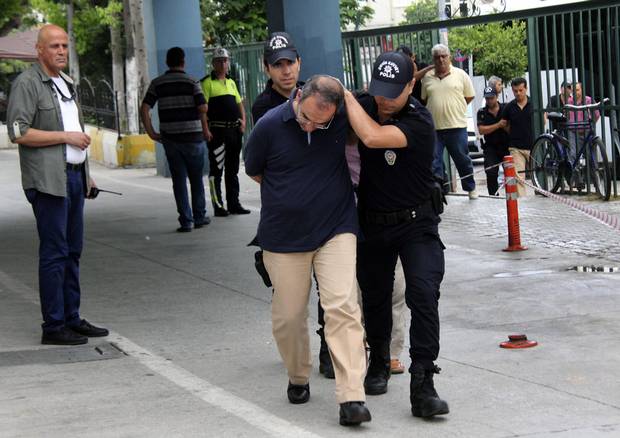 Police officers escort admiral Atilla Demirhan, front, and a group of millitary personal detained in Mersin, Turkey, Tuesday, July 19, 2016.