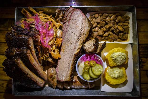 The Lone Star Platter - brisket, full rack pork and one hot link with corn bread and smoked brisket beans on the side at Dixie'sBBQ in Vancouver.