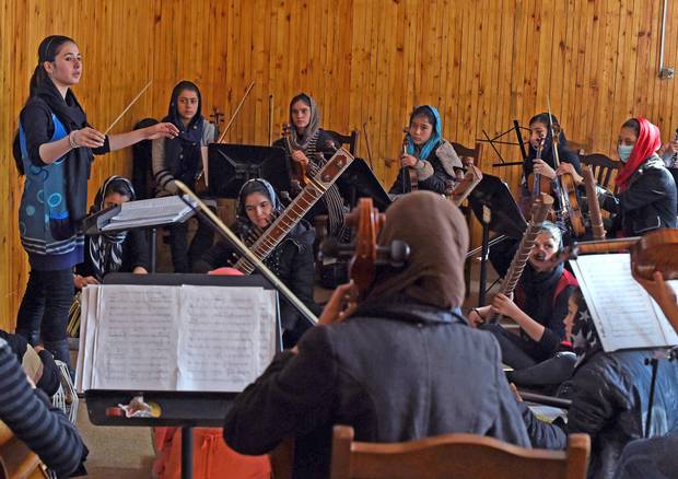 Nineteen year-old Negina Khpalwak, the first female orchestra conductor in Afghanistan, conducts her musicians during a rehearsal at the Afghanistan National Institute of Music in Kabul on Jan. 8, 2018.