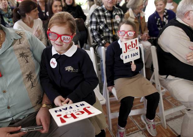 Twin sisters, Riley (left) and Reagan Gregg of Summerville, play with campaign fans before a campaign stop by U.S. Republican presidential candidate Jeb Bush at the Summerville Country Club in Summerville, South Carolina.