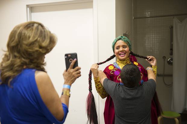 Pimienta, gets a hug from nephew Orlando Pimienta, 6, as her mother, Rosario Paz, shows her a photo.