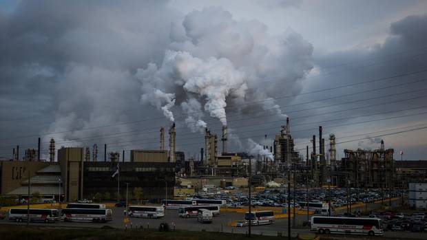 Buses drop off workers at the Syncrude Mildred Lake plant, near Fort McKay, Alta., in the early-morning hours of Sept. 16, 2014.