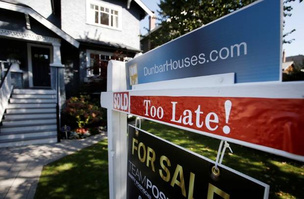 A real estate for sale sign is pictured in front of a home in Vancouver.