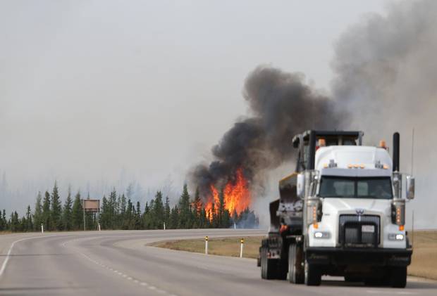 Flames rise off Highway 63 on Saturday outside Fort McMurray.