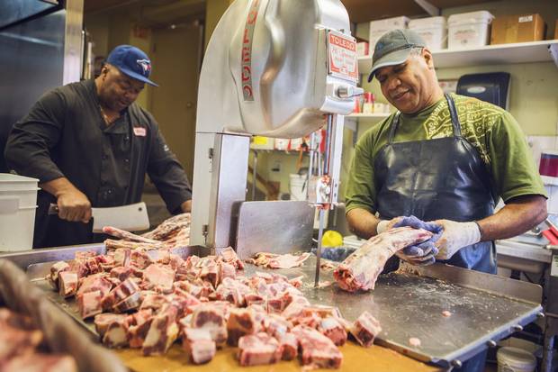 Anthony Bonnuck and Courtney Brown chop up ox tail at Albert's Real Jamaican Foods.
