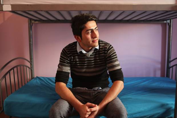Mikahil Akbary looks out the window of the room he shares with two other refugees in Suresnes.