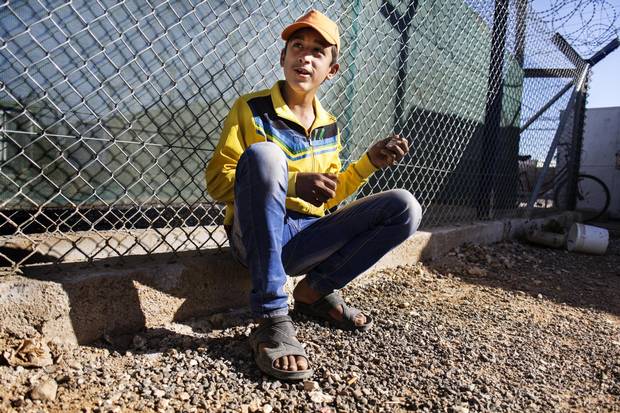 Bashar Ibrahim, 13, breaks an electrical transformer to construct a toy house for children in the camp.