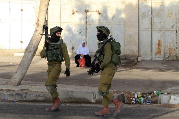 Israeli soldiers patrol a street, east of the West Bank city of Nablus, on Oct. 3, 2015, as they search for the suspected Palestinian killers of a Jewish settler couple.