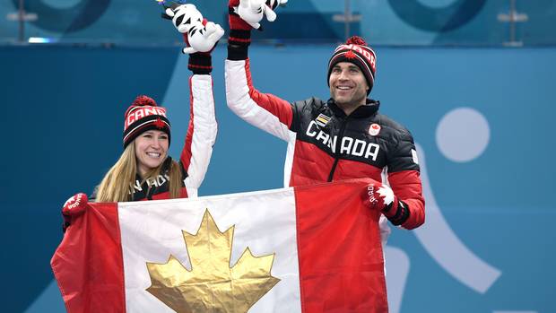 Canada's Kaitlyn Lawes and Canada's John Morris hold the Canada flag on the podium after winning the gold medal in mixed curling at the Pyeongchang 2018 Winter Olympic Games on February 13, 2018.