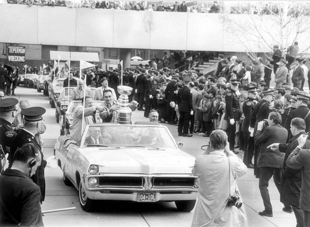 The Toronto Maple Leafs victory parade arrives at City Hall on May 5, 1967, with captain George Armstrong holding the Stanley Cup, escorted by Harold Ballard, executive vice-president of Maple Leaf Gardens and Stafford Smythe, president. (Punch Imlach is in the car behind them.)