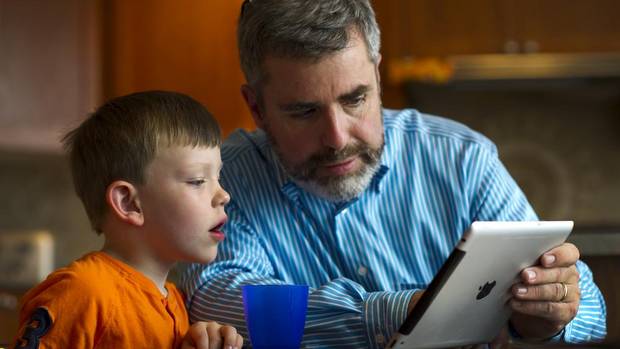 Stephen Hurley and his son Luke, 5, learn about butterflies on an iPad in Milton, Sept. 5, 2012.