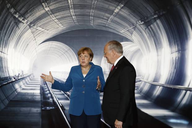 Swiss Federal President Johann Schneider-Ammann, right, listens to German Chancellor Angela Merkel on the opening day of the Gotthard rail tunnel in Erstfeld, Switzerland, on June 1, 2016.