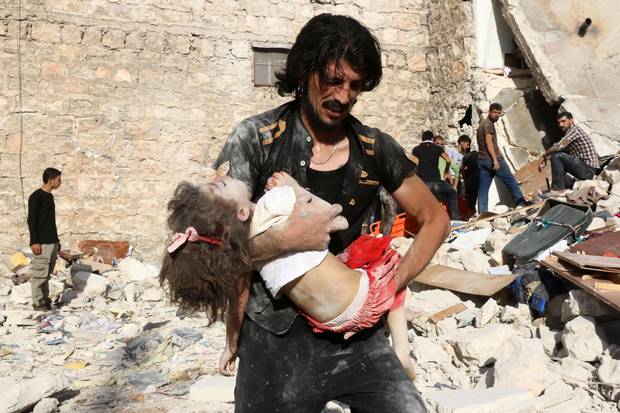 A Syrian man carries a child who was retrieved under the rubble of a collapsed building following a reported air strike on the rebel-held neighbourhood of Sakhur in the northern city of Aleppo on July 19, 2016. Civilians in rebel-held parts of Syria's Aleppo expressed fears on July 18, 2016 of a lengthy government siege, as food supplies dwindled after regime troops seized the only road into the city's east. The government advance, which has been backed by a Russian air offensive, is seen as a major setback for opposition forces in Syria's second city.