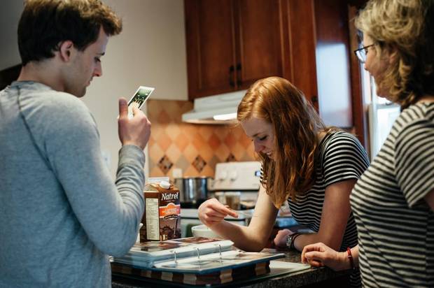 Sherri Elms and her children Jake and Stephanie looking through old family photos at their home in Kingston.