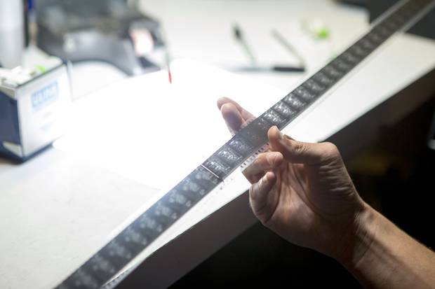A reel of film from Stray Dog is inspected for damage at the TIFF Bell Lightbox.