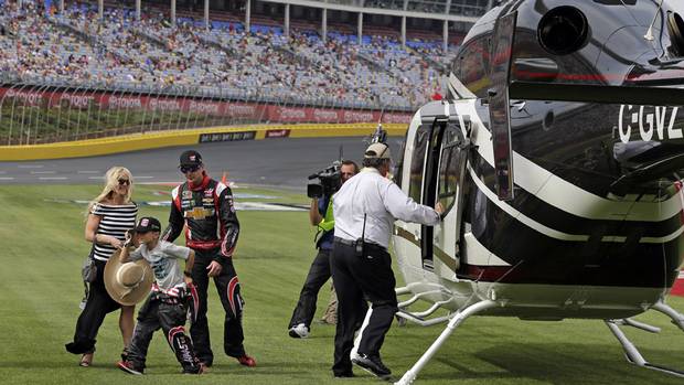 Driver Kurt Busch, right, arrives with girlfriend Patricia Driscoll, left, and her son, Houston, centre, for the NASCAR Sprint Cup series Coca-Cola 600 auto race at Charlotte Motor Speedway in Concord, N.C., Sunday, May 25, 2014. Busch finished sixth in the Indianapolis 500 race earlier.