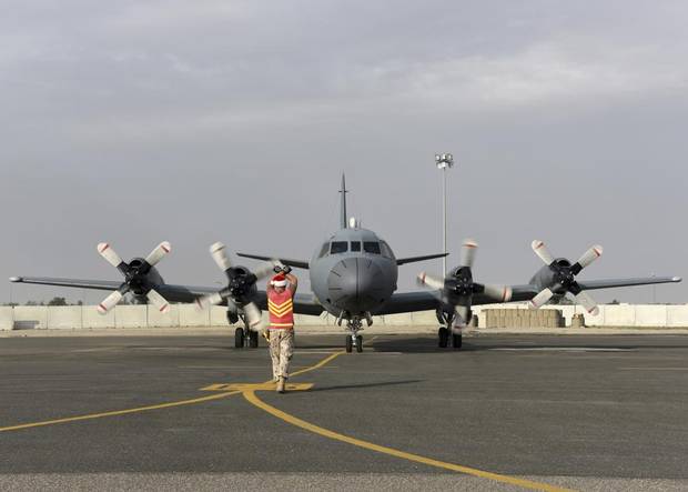 An aircraft technician from Air Task Force – Iraq marshals a CP-140 Aurora aircraft into Camp Canada in Kuwait on December 12, 2015 during Operation IMPACT.
